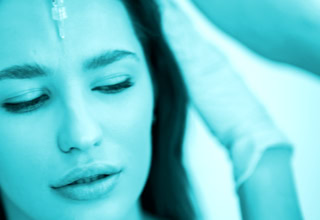 Frau mit geschlossenen Augen, eine Hand in einem Handschuh berührt ihr Haar, blaue Farbton.